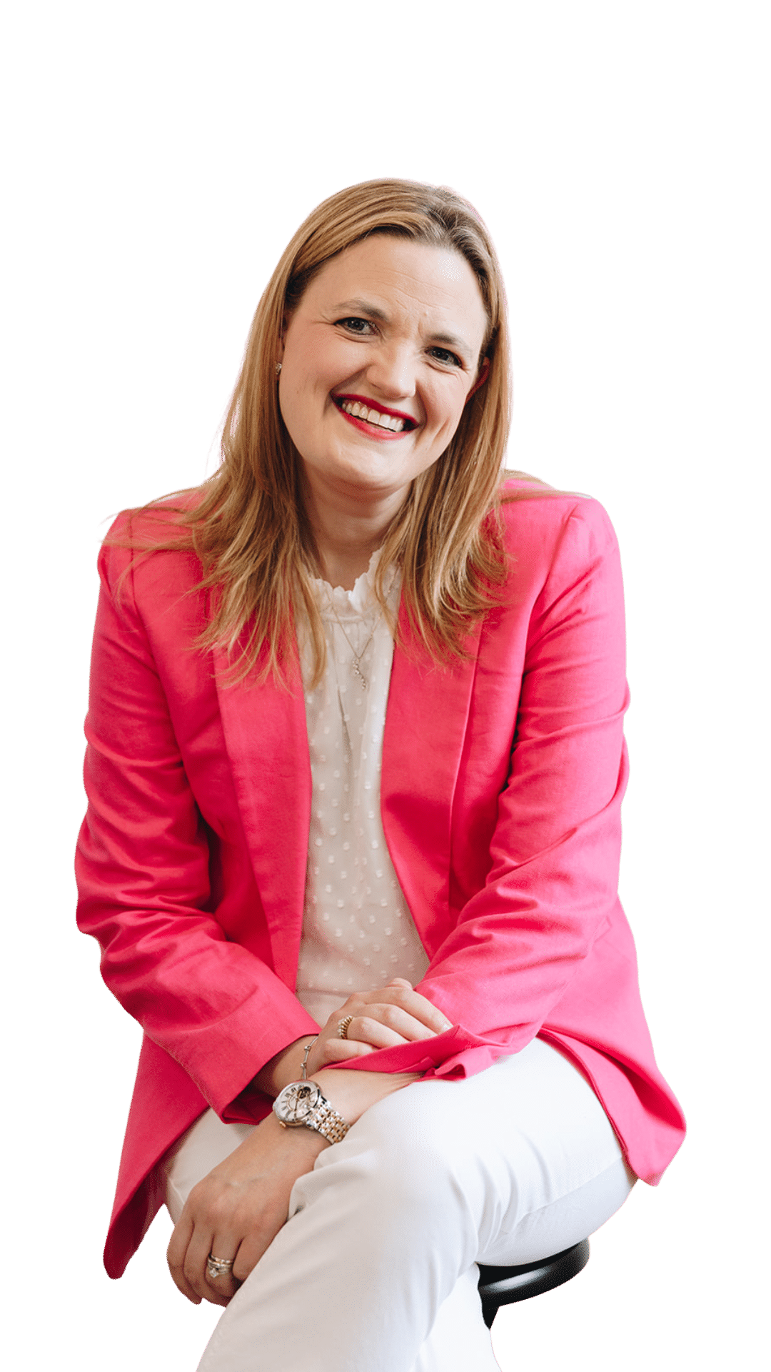 Brooke for Overlay Brooke Greening, a sales coach, smiling and sitting, wearing a pink blazer and white blouse.